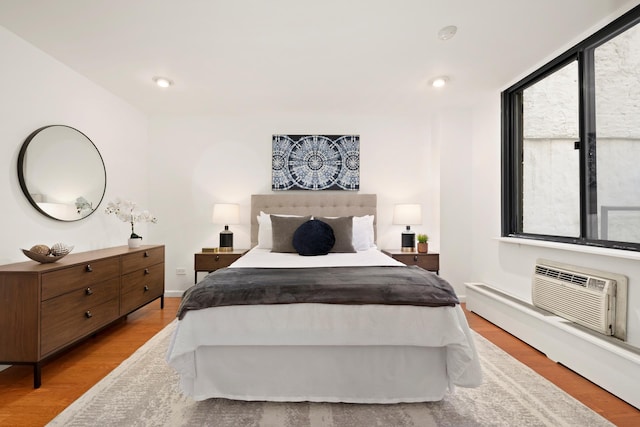 16 W 16th St Unit 1Ds, New York City, NY 10011 - bedroom with light wood-style flooring, multiple windows, a wall mounted air conditioner, and recessed lighting