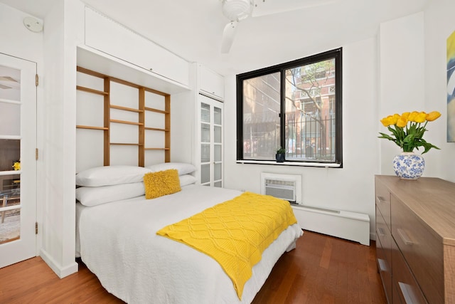 16 W 16th St Unit 1Ds, New York City, NY 10011 - bedroom with wood finished floors, a baseboard radiator, and a wall mounted air conditioner