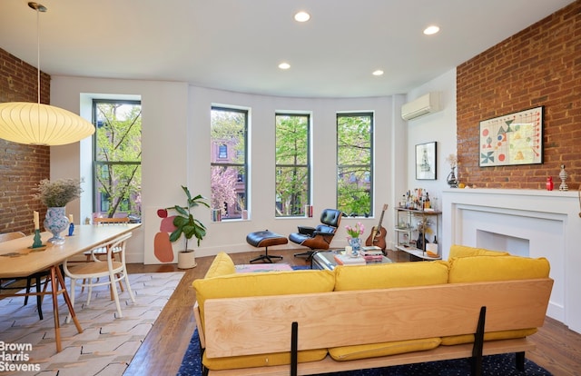 living area featuring an AC wall unit, plenty of natural light, and hardwood / wood-style floors