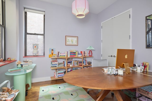 dining space with baseboards and wood finished floors