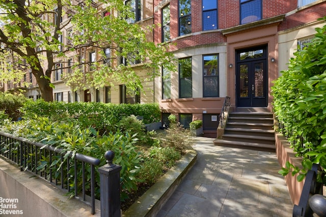 view of exterior entry with brick siding and french doors