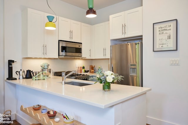 kitchen with a sink, appliances with stainless steel finishes, and white cabinets