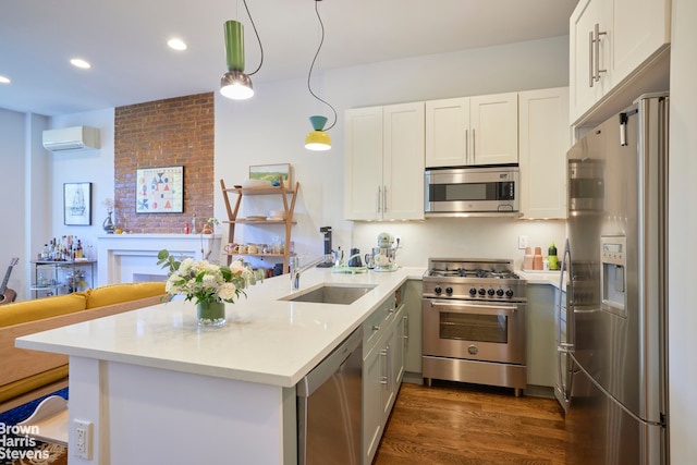 kitchen featuring a peninsula, an AC wall unit, dark wood-type flooring, a sink, and stainless steel appliances