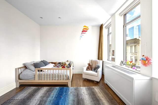 bedroom featuring wood finished floors and baseboards