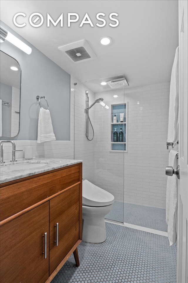 full bathroom with vanity, toilet, tile patterned floors, visible vents, and tiled shower