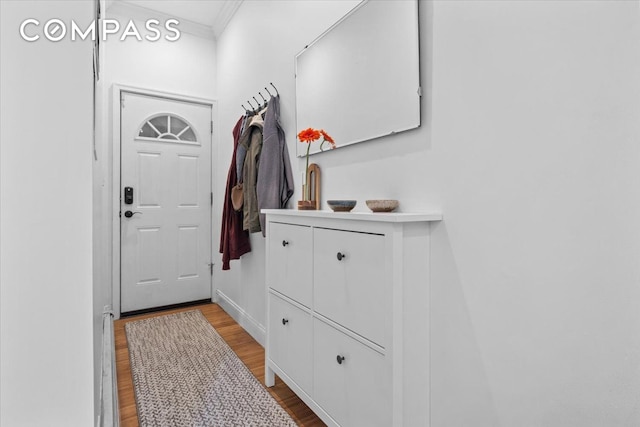 mudroom with baseboards, ornamental molding, and wood finished floors
