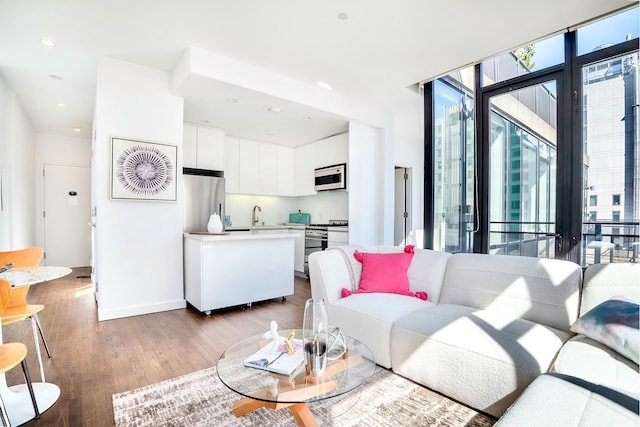 living room with recessed lighting, wood finished floors, and a wealth of natural light
