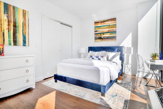 bedroom with a closet, baseboards, and wood finished floors