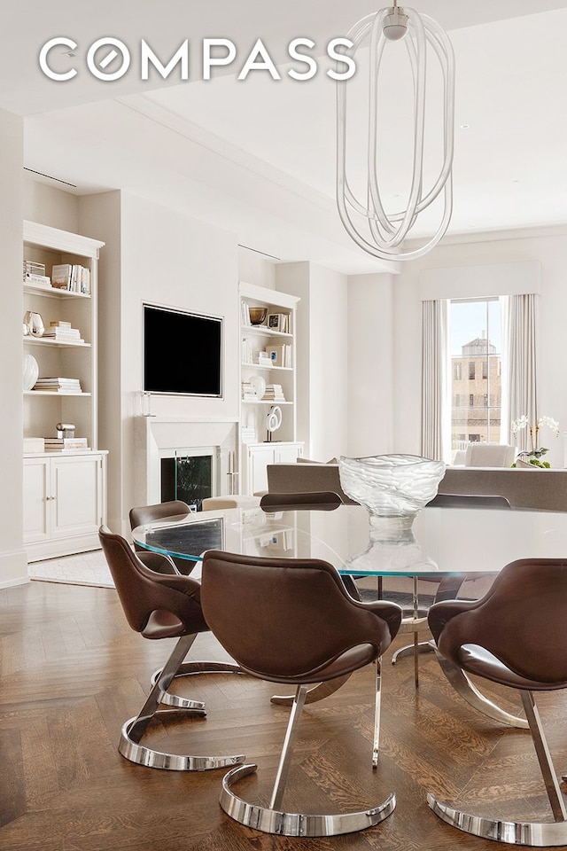 dining area featuring an inviting chandelier, built in shelves, and a fireplace