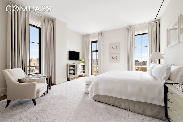 bedroom featuring baseboards and multiple windows
