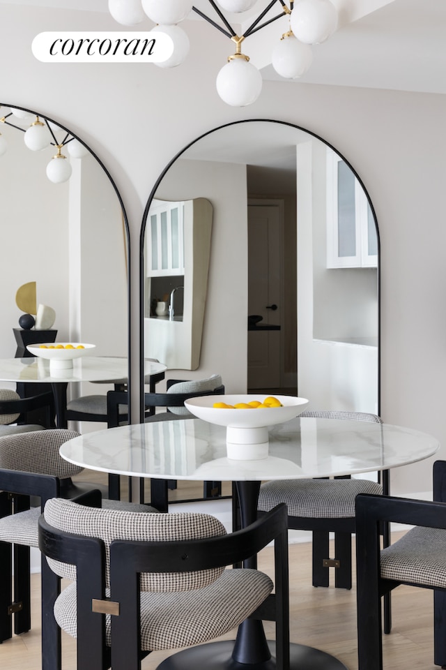 210 Warren St Unit 7A, New York City, NY 10282 - dining space featuring light wood-style flooring and arched walkways