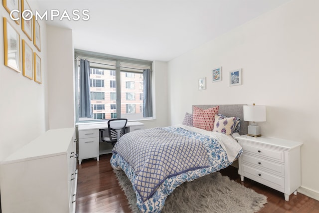 bedroom with baseboards and dark wood finished floors