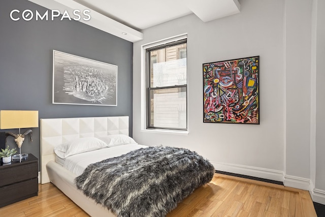 bedroom featuring baseboards and wood finished floors