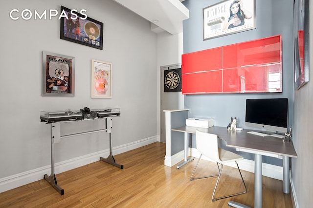 office space with baseboards and light wood finished floors