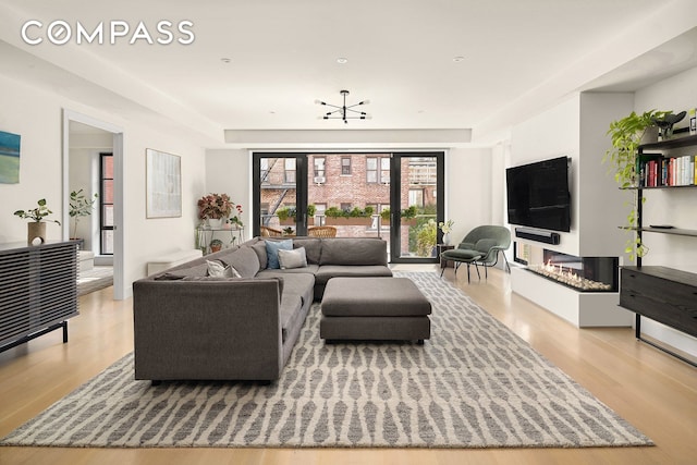 living area with a glass covered fireplace and wood finished floors