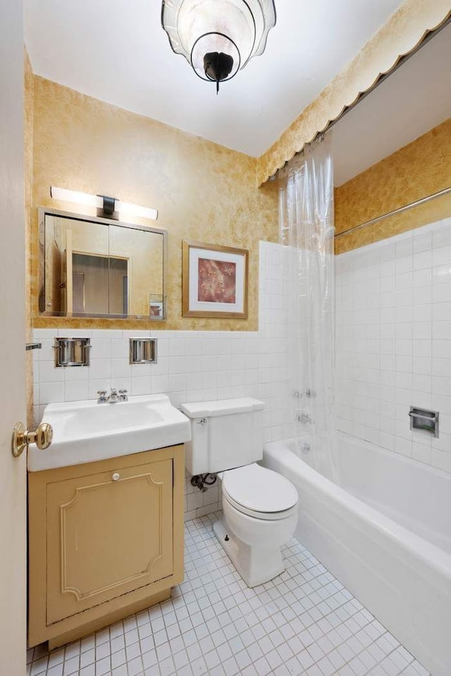 full bathroom with tile patterned flooring, vanity, toilet, tile walls, and washtub / shower combination