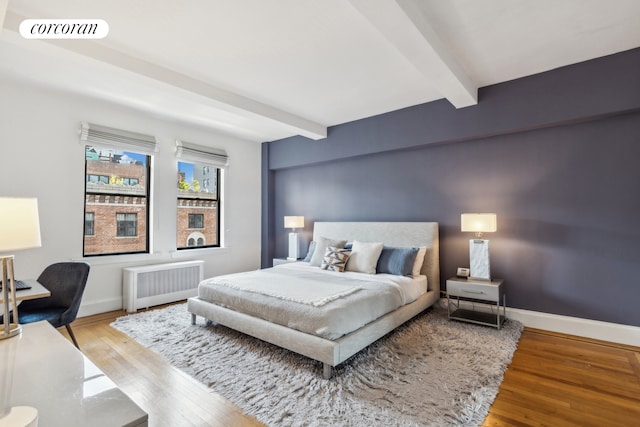 40 W 72nd St Unit 62, New York City, NY 10023 - bedroom with radiator heating unit, beamed ceiling, wood finished floors, and baseboards