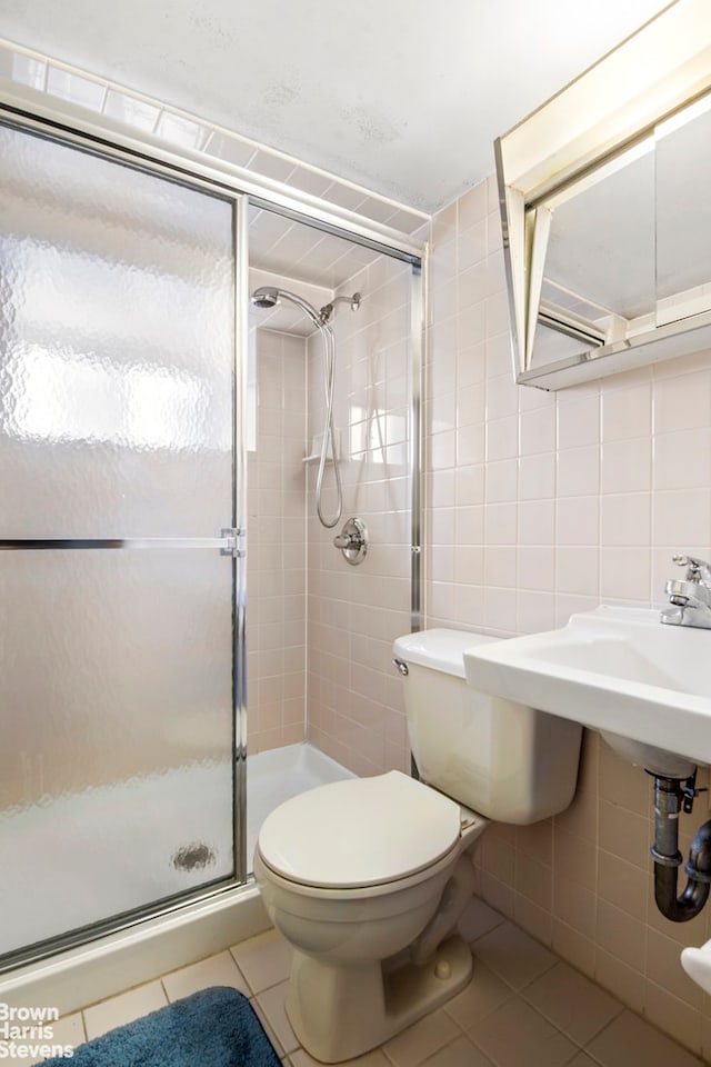 full bath with tile walls, tile patterned flooring, a stall shower, and toilet