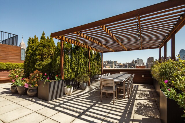 view of patio featuring a view of city, a pergola, and outdoor dining area