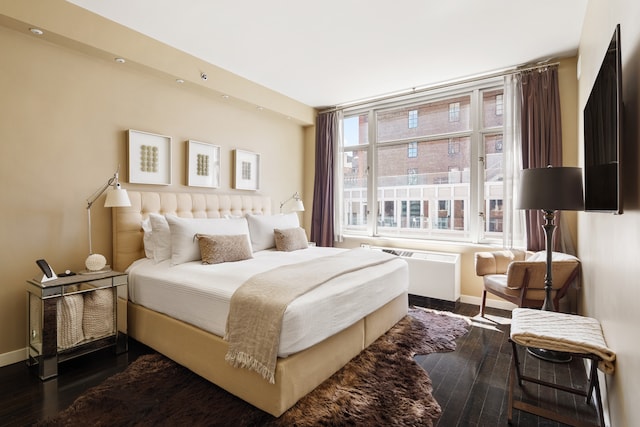bedroom featuring baseboards, radiator, and dark wood-style flooring