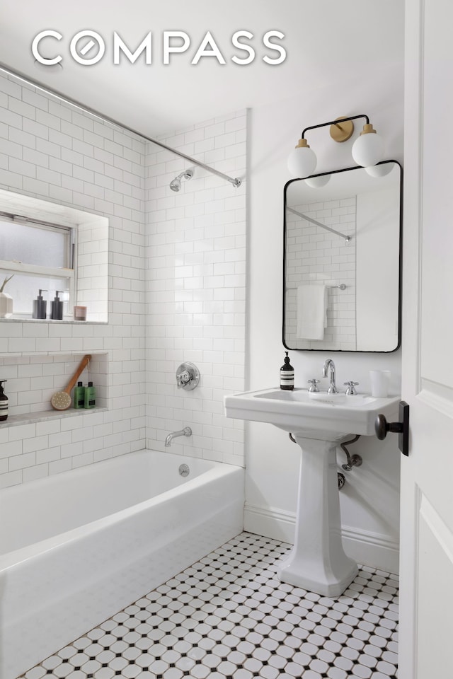 bathroom featuring baseboards and washtub / shower combination