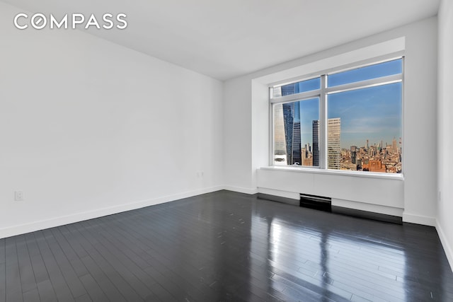 123 Washington St Unit 52F, New York City, NY 10006 - unfurnished room with baseboards and dark wood finished floors