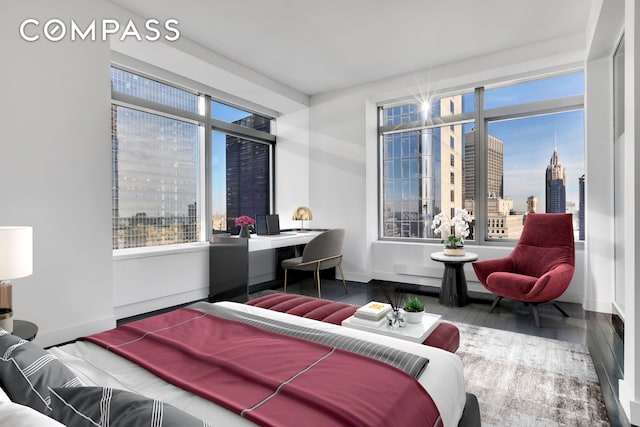 123 Washington St Unit 52F, New York City, NY 10006 - bedroom featuring a desk, wood finished floors, baseboards, and a view of city