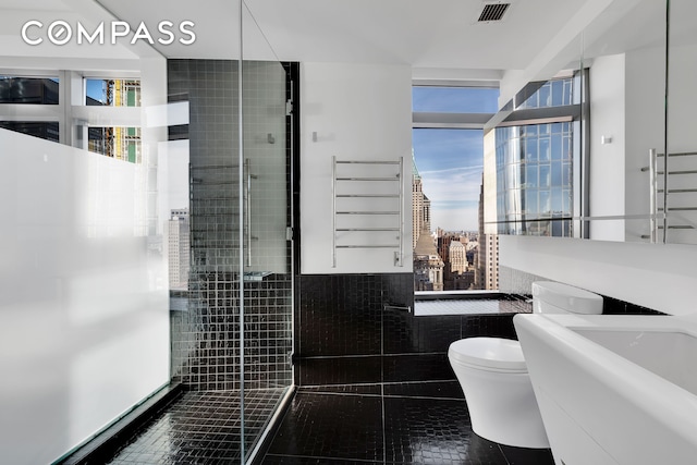 123 Washington St Unit 52F, New York City, NY 10006 - full bath featuring toilet, tile patterned floors, a sink, tiled shower, and a city view