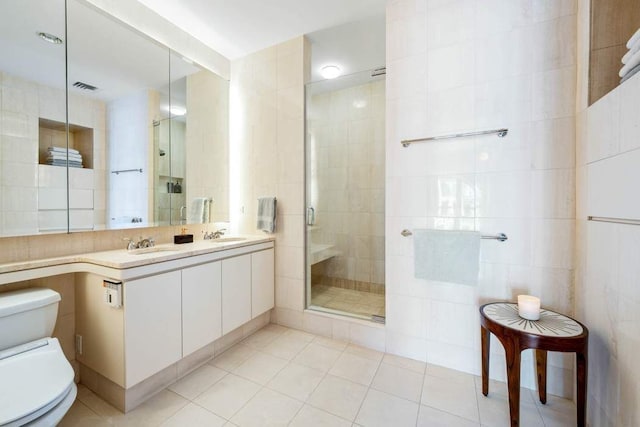 65 W 13th St Unit 9B, New York City, NY 10011 - bathroom featuring toilet, tile walls, a stall shower, tile patterned floors, and double vanity