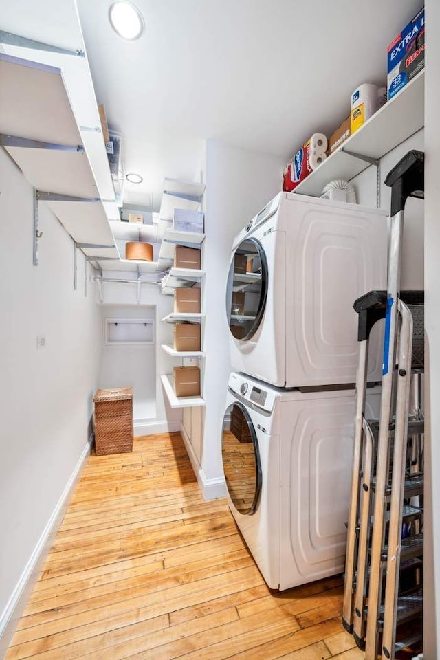 65 W 13th St Unit 9B, New York City, NY 10011 - laundry room featuring estacked washer and dryer, baseboards, light wood-style flooring, and recessed lighting
