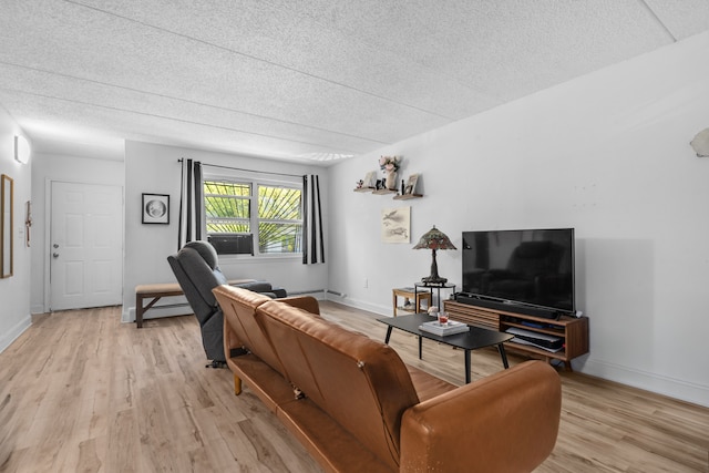 living room featuring light wood-style floors, a textured ceiling, baseboards, and baseboard heating