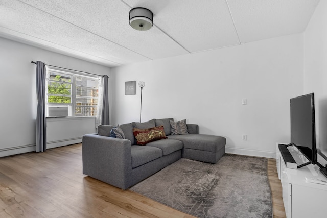 living area featuring a baseboard radiator, wood finished floors, and cooling unit