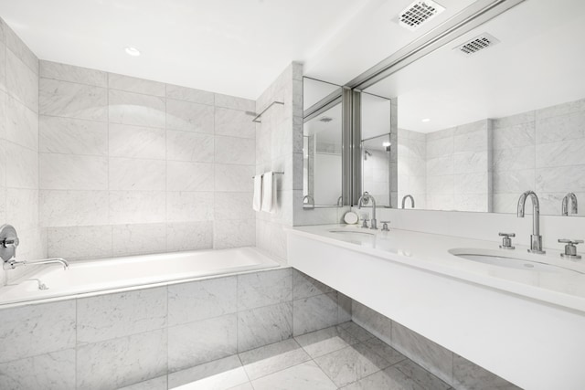 35 Sutton Pl Unit 20A, New York City, NY 10022 - full bath with tiled tub, double vanity, tile walls, tile patterned flooring, and tiled shower