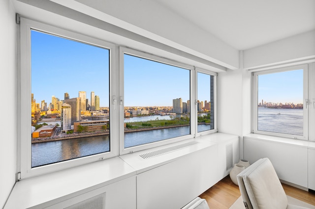 sunroom featuring a view of city and a water view