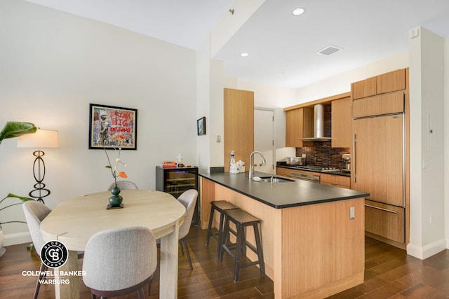 70 Little W St Unit 5C, New York City, NY 10280 - kitchen featuring a sink, paneled refrigerator, wall chimney range hood, dark countertops, and dark wood finished floors