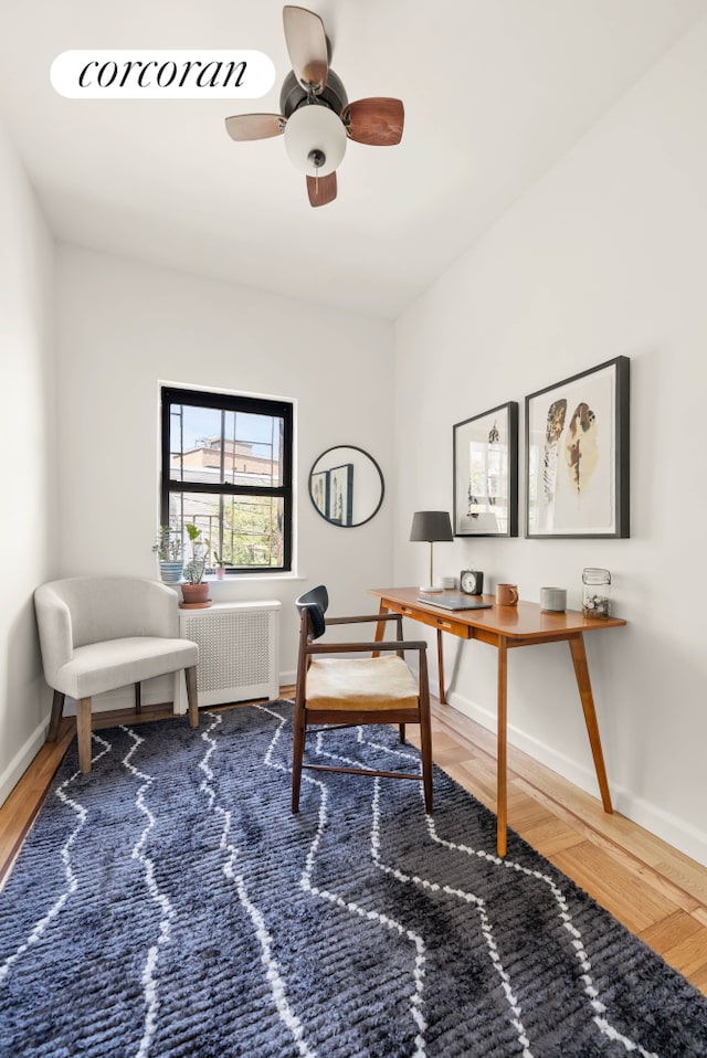 office area featuring a ceiling fan, baseboards, and wood finished floors