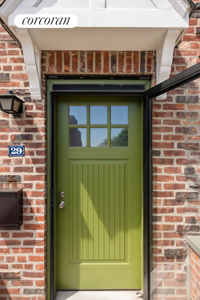 entrance to property featuring brick siding