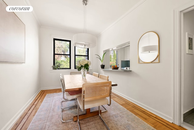 dining area featuring baseboards, visible vents, ornamental molding, and light wood-type flooring