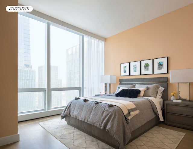 bedroom with multiple windows and wood finished floors