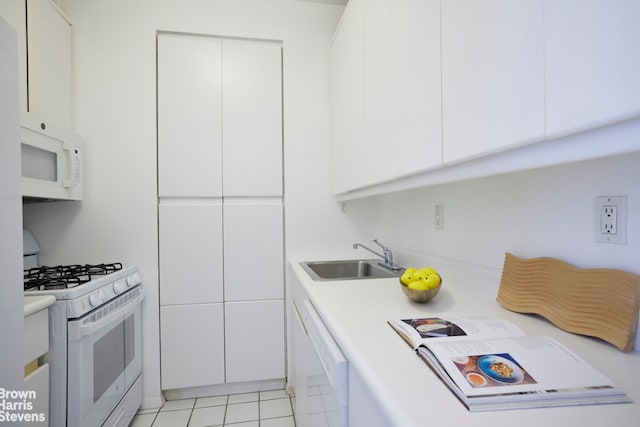 kitchen with a sink, light countertops, white appliances, and white cabinetry