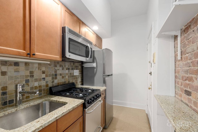 175 Amity St Unit A4, New York City, NY 11201 - kitchen with appliances with stainless steel finishes, a sink, decorative backsplash, baseboards, and light stone counters