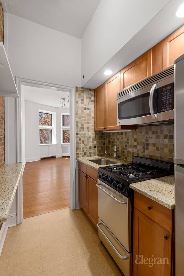 175 Amity St Unit A4, New York City, NY 11201 - kitchen with appliances with stainless steel finishes, a sink, tasteful backsplash, and brown cabinets