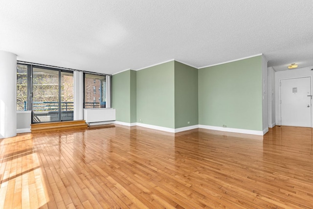 unfurnished living room featuring baseboards, a textured ceiling, and hardwood / wood-style flooring
