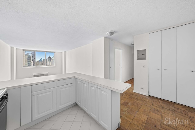 kitchen featuring light countertops, a textured ceiling, and white cabinetry