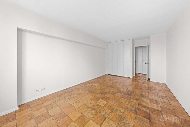 unfurnished bedroom with baseboards and a closet