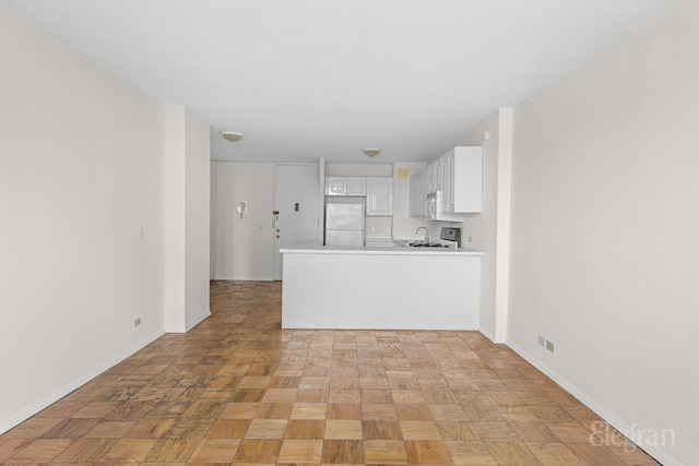 unfurnished living room featuring baseboards