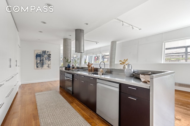 245 10th Ave Unit 2W, New York City, NY 10001 - kitchen featuring stainless steel appliances, rail lighting, dark brown cabinets, modern cabinets, and light wood-style floors