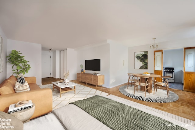 living area with an inviting chandelier, a wood stove, and baseboards