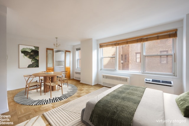 bedroom featuring a chandelier, baseboards, a wall mounted AC, and radiator heating unit