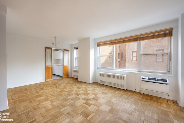 spare room with baseboards, heating unit, radiator, and an inviting chandelier